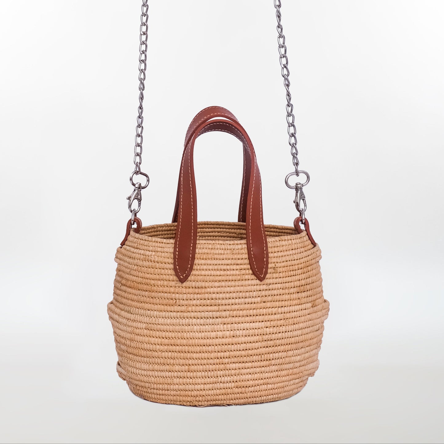 Mini raffia tote bag with brown leather handles and detachable silver chain shoulder strap