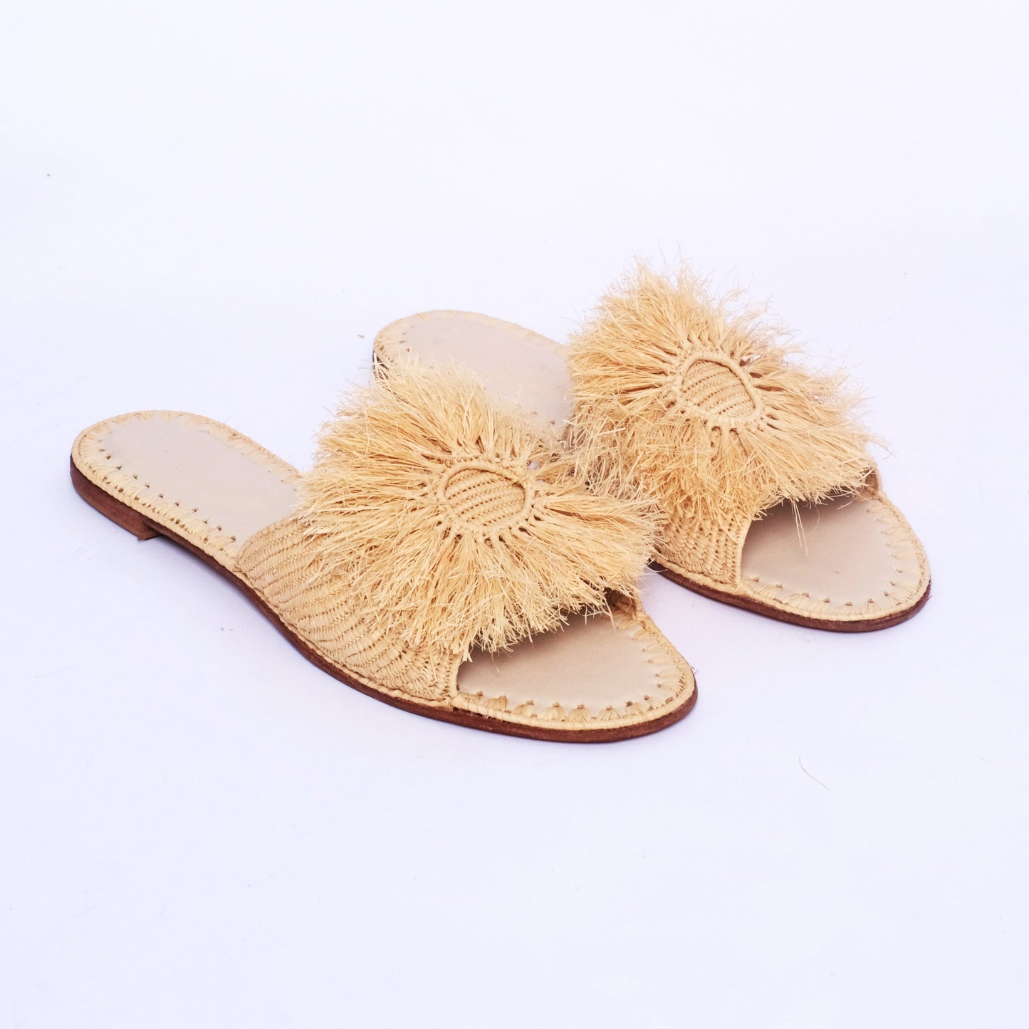 Natural raffia slides for women, handmade in Morocco with leather insole and fringe detail.