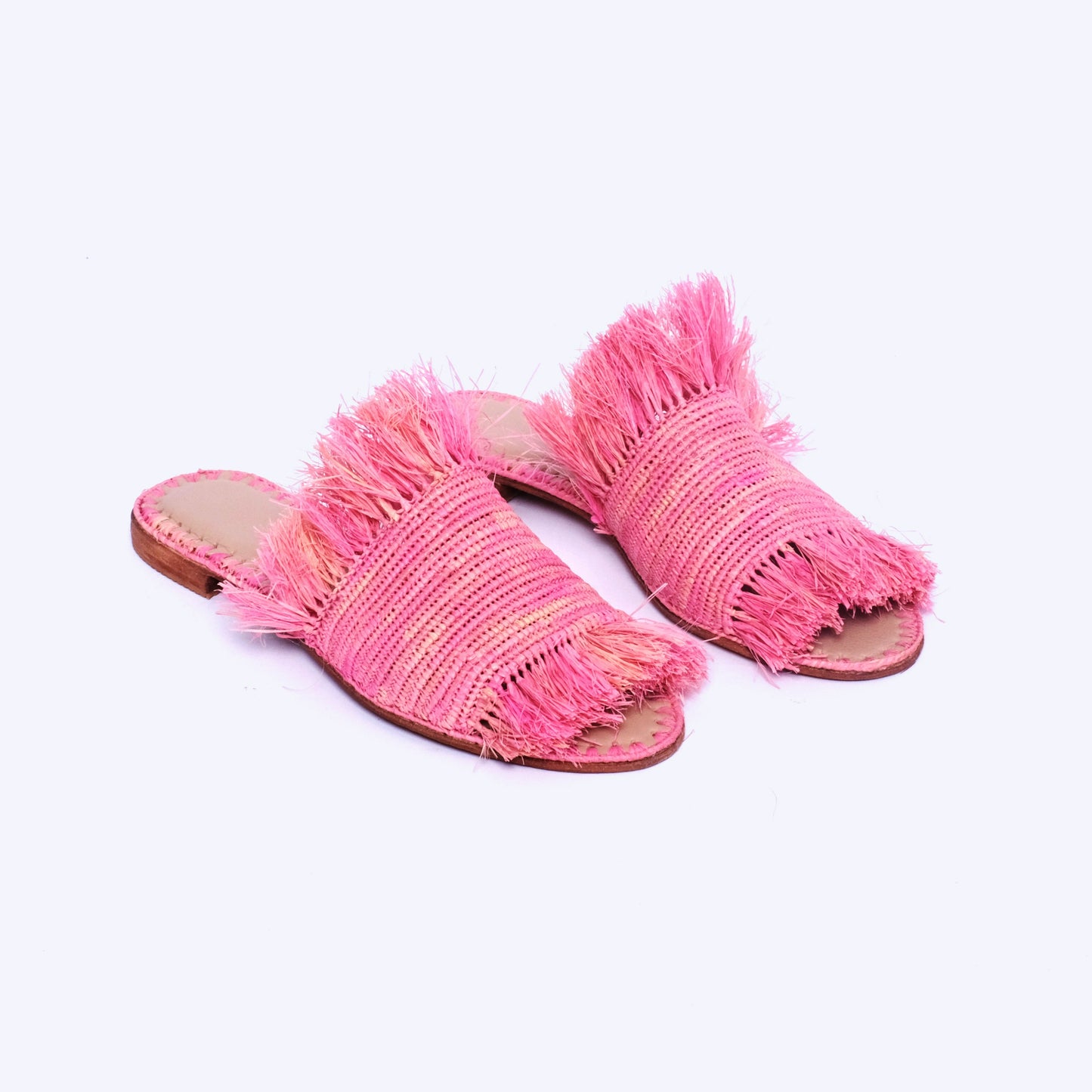 Pink handwoven raffia fringe sandals with flat leather soles and open toe