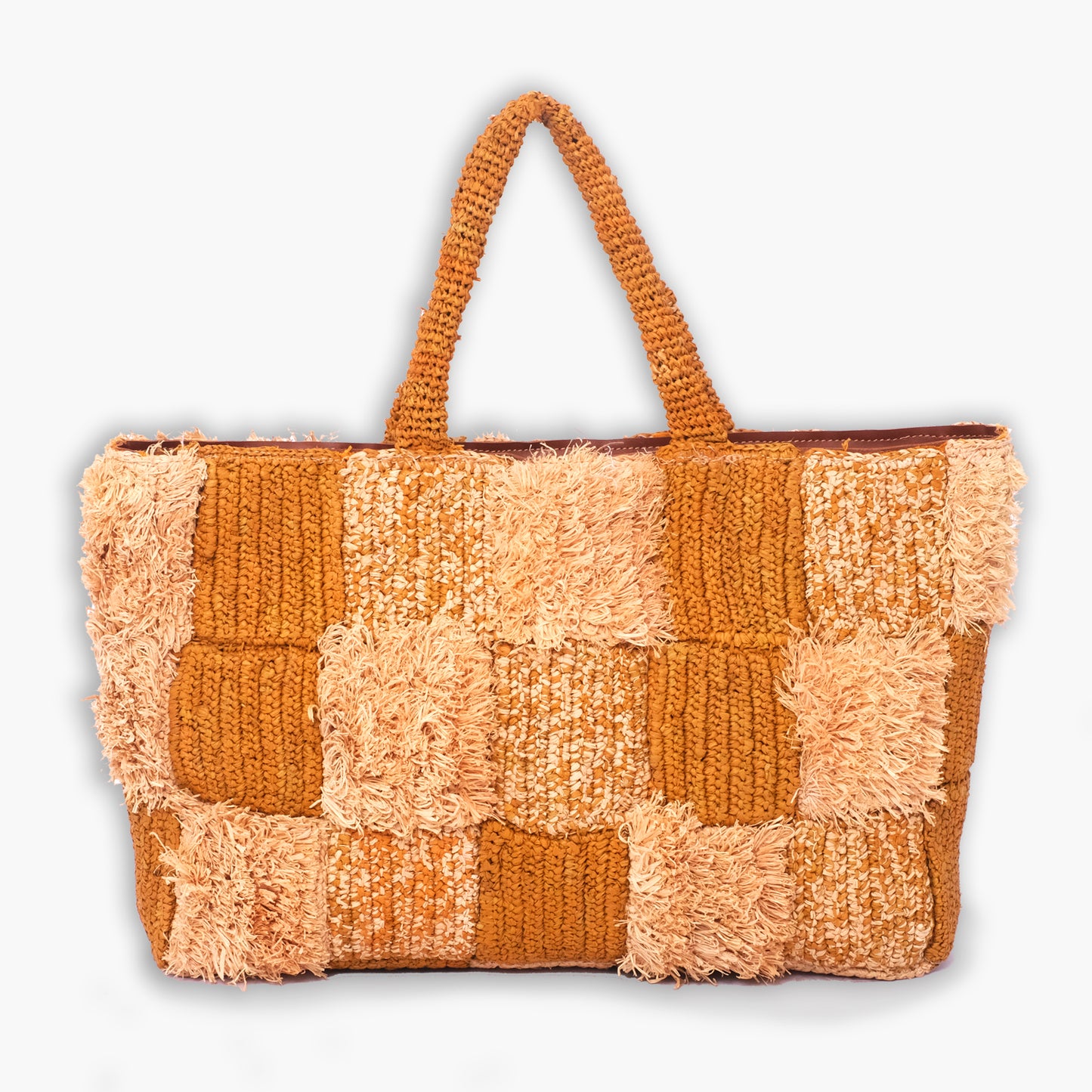 Patchwork tote bag with alternating textured squares in orange and cream yarn, shag details, and knitted handles