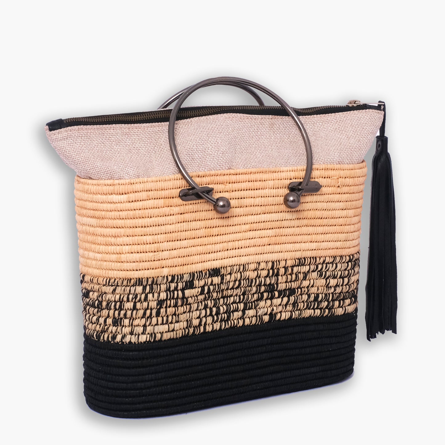 Colorblocked raffia tote bag with round metal handles, black and natural weave, and zipper closure