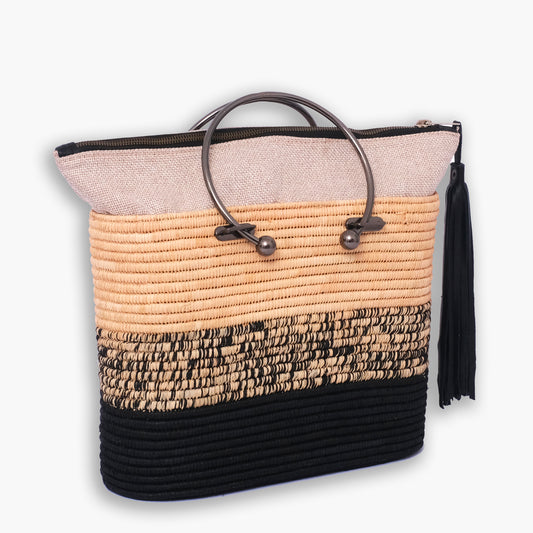Colorblocked raffia tote bag with round metal handles, black and natural weave, and zipper closure