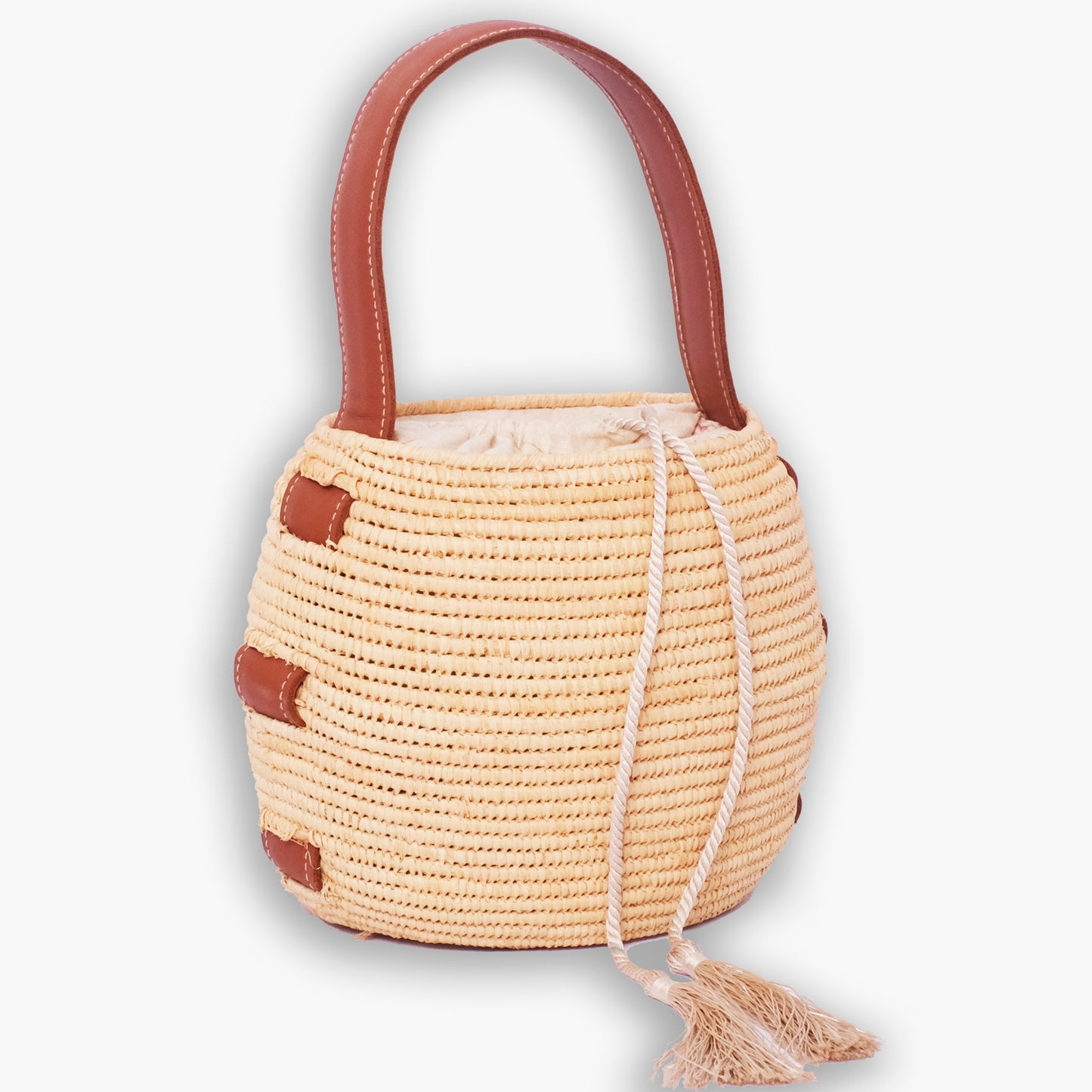 Handwoven natural raffia bucket bag with brown leather handles and drawstring closure