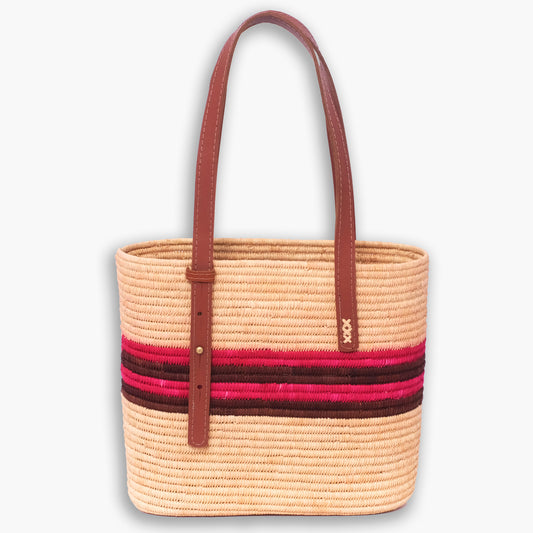 Handwoven raffia shoulder tote with pink and brown horizontal stripes and long brown leather straps