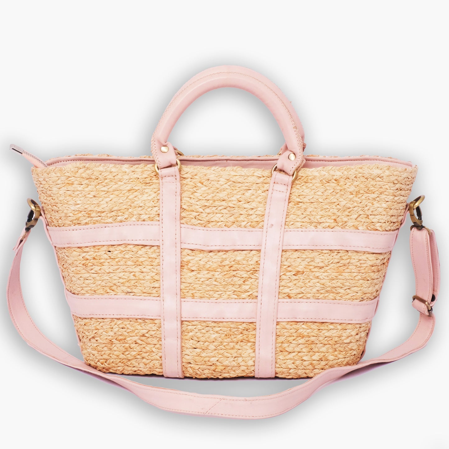 Structured straw tote bag with pink leather trim, top handles, and adjustable shoulder strap