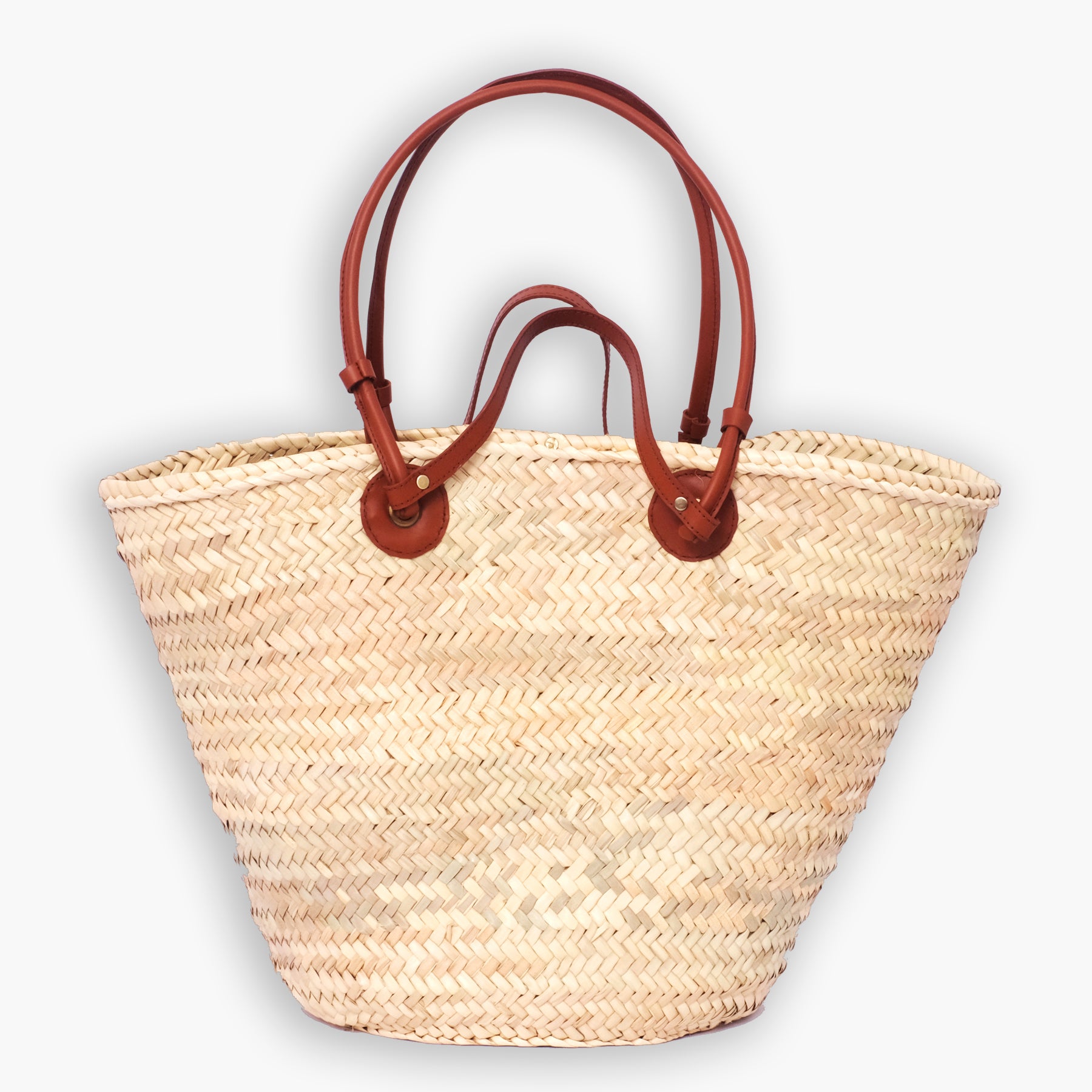Classic Moroccan straw tote bag with round leather anchor patches and double-loop handles, photographed on white background.