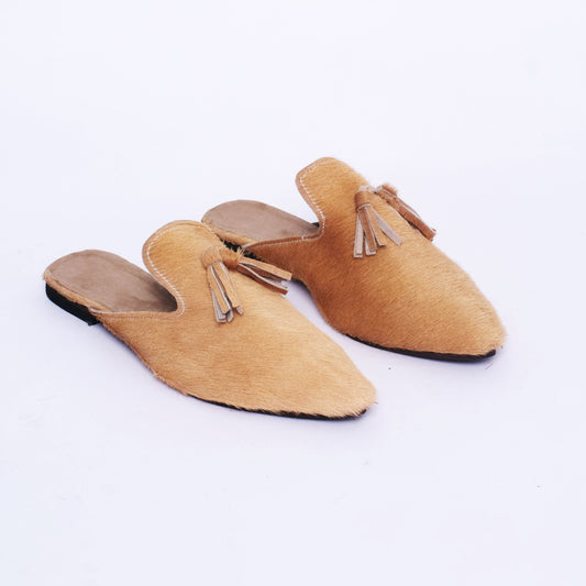 Women’s handmade slip-on mules with natural hair-on leather upper, pointed toe, and leather tassel detail, crafted in Morocco.