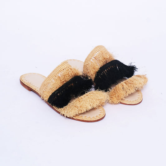 Pair of handmade women's raffia slides with black and natural fringe, crafted in Morocco
