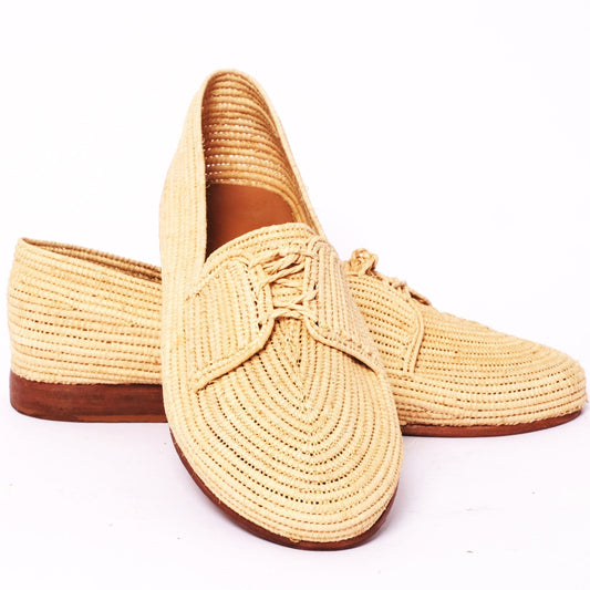 Pair of beige woven shoes on a white background