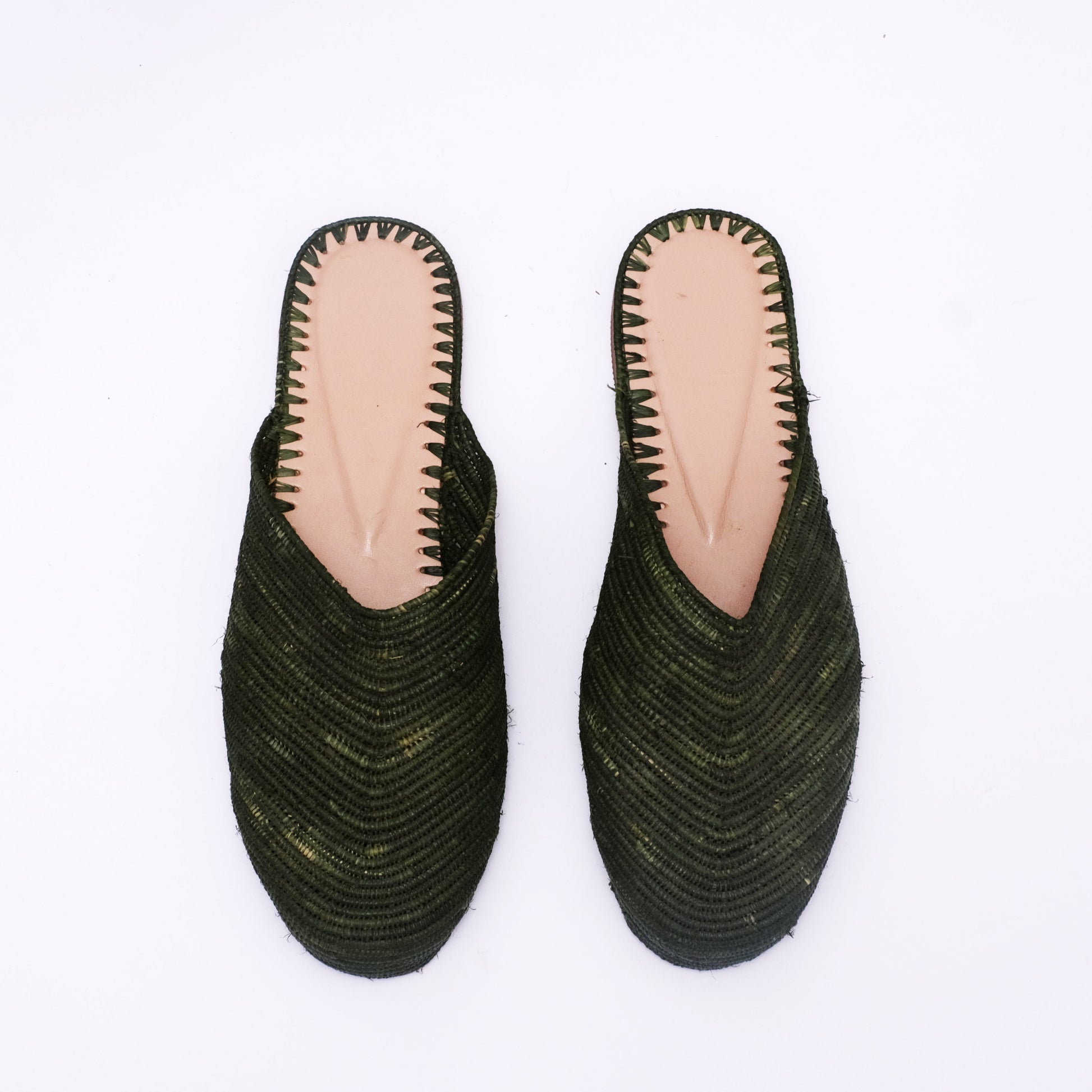Women’s dark green raffia mules with V-cut front and natural leather insole, handwoven in Morocco from palm fiber.