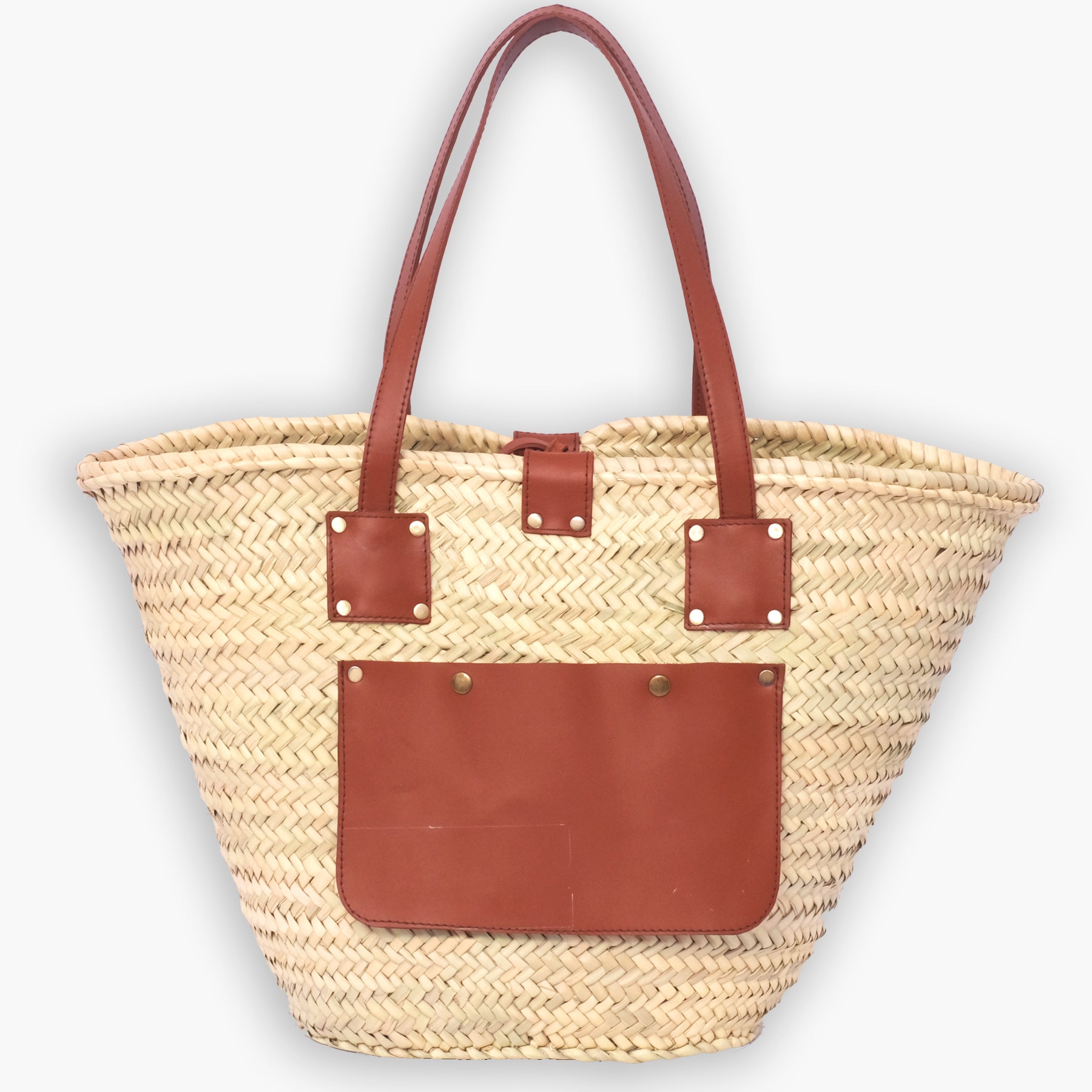 Moroccan straw tote bag with square leather strap anchors and a large front leather pocket, photographed on a white background.